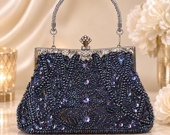 May include: A dark blue evening handbag featuring an intricate pattern of iridescent beads and sequins. The bag has a silver-toned metal frame with a decorative clasp, a textured silver handle, and a structured shape with a flat base.