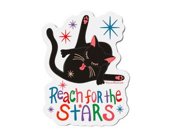 May include: A black cat with pink paws and a pink tongue is licking its fur. The cat is lying on its back with its legs in the air. The background is white with colourful stars. The text "Reach for the *STARS*" is written below the cat.