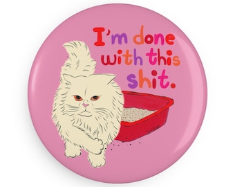 May include: A pink badge featuring the text "I'm done with this shit" in various colours. A cartoon cat with an angry face stands near a red litter tray.
