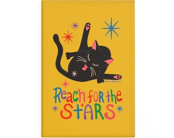Op de afbeelding: Een rechthoekige magneet met een mosterdgele achtergrond met een zwarte kat die zichzelf wast. De kat is omringd door kleurrijke sterren. Onder de kat staat de tekst Reach for the STARS in veelkleurige, speelse letters.