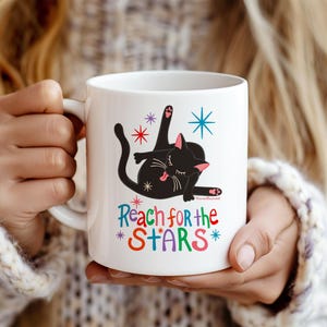 Taza divertida con diseño de trasero de gato "Reach for the Stars", taza de café con gatito negro original, regalo sarcástico para amantes de los gatos, vajilla de oficina con un toque de humor.