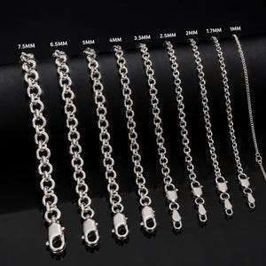 May include: A collection of nine silver-toned rolo chains arranged by thickness, labeled from 1mm to 7.5mm. Each chain features a lobster claw clasp at the bottom. The chains are displayed vertically against a dark background, showing varying link sizes.