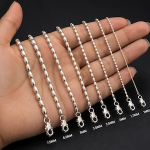 May include: A collection of eight silver-toned ball chains arranged by size, ranging from 1mm to 7.5mm in diameter. Each chain features a lobster claw clasp at the end, with the specific measurement clearly printed below each individual chain.