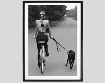 Poster vrouw rijdende fiets met hond, zwart-wit minimalistische wielerkunst, stedelijke lifestyle fotografie wanddecoratie