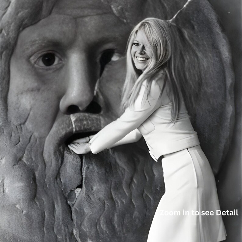 May include: A monochrome photograph featuring a woman in a white suit posing beside a large stone sculpture of a face. The woman is smiling and touching the sculpture's mouth. The image has a vintage feel.