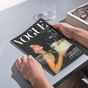 May include: A person holding a Vogue magazine. The cover features a woman holding a birthday cake. The magazine's title is "VOGUE" with the text "21 Birthday Edition". The cover also includes the text "Glam, Style & Heartfelt".