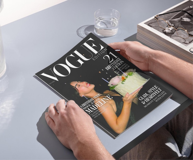 May include: A person holding a Vogue magazine. The cover features a woman holding a birthday cake. The magazine's title is "VOGUE" with the text "21 Birthday Edition". The cover also includes the text "Glam, Style & Heartfelt".