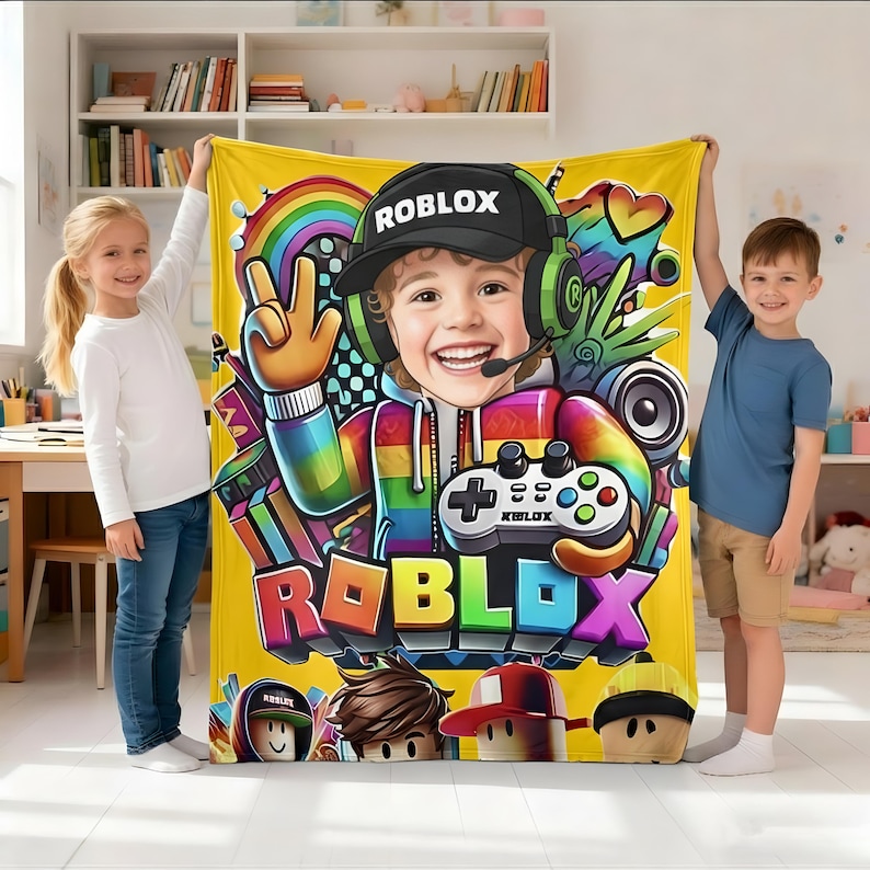 May include: A yellow fleece blanket featuring a central graphic of a smiling child wearing a black Roblox cap and green headphones, holding a game controller. The design includes a rainbow-colored hoodie, a rainbow, and the word Roblox in bold letters.