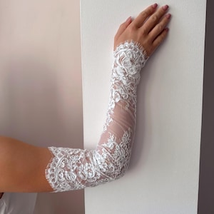 Close up of fingerless lace wedding sleeves, floral embroidery on sheer fabric