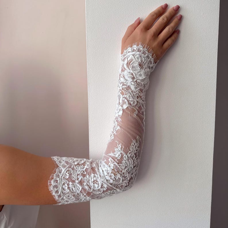 Close up of fingerless lace wedding sleeves, floral embroidery on sheer fabric
