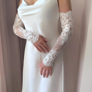 Fingerless bridal lace sleeves worn with minimalist satin wedding dress, sheer floral lace detail