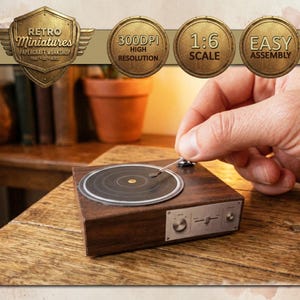 May include: A miniature wooden record player with a silver tone needle and control panel. The record player is on a wooden surface. The image includes text that says "Retro Miniatures Papercraft Workshop".