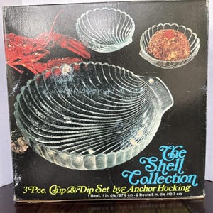 May include: A vintage Anchor Hocking "Shell Collection" chip and dip set. The set includes a large shell-shaped bowl (11 in. dia) and two smaller shell-shaped bowls (5 in. dia). The box features a lobster illustration and the text "The Shell Collection".