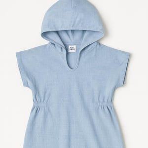 Könnte beinhalten: Hellblaues Kapuzenkleid mit kurzen Ärmeln und elastischer Taille. Das Kleid hat einen V-Ausschnitt und eine Kapuze. Das Markenlogo ist am Ausschnitt sichtbar. Hergestellt aus weichem, leichtem Stoff.