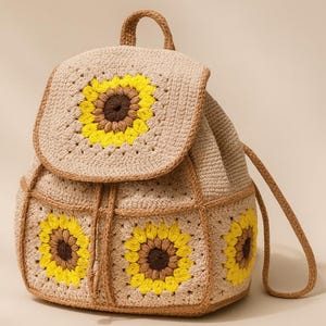 Puede incluir: Mochila de crochet beige con tres diseños de girasoles con pétalos amarillos y centros marrones. La bolsa tiene un cierre de solapa y correas ajustables. La mochila mide aproximadamente 30 cm de alto y 25 cm de ancho.