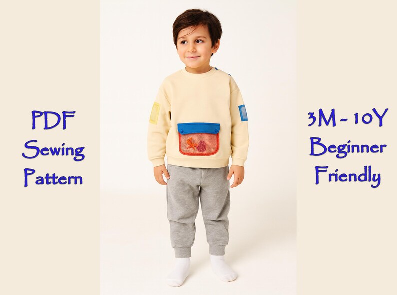 May include: A child wearing a light yellow sweatshirt with a blue pocket and a fish design. The sweatshirt has patches of blue and yellow. The child is also wearing gray sweatpants and white socks. Text on the left says "PDF Sewing Pattern" and on the right "3M-10Y Beginner Friendly".