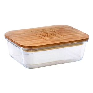 May include: A rectangular clear glass food storage container with a light brown bamboo lid. The lid features a laser-engraved logo with the text YOGIK centered within a rectangular border. The container has rounded corners and a flat top surface.