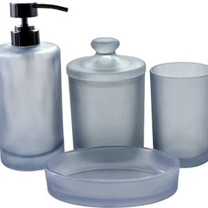 Könnte beinhalten: Ein Badezimmer-Set in mattiertem Hellblau. Das Set umfasst einen Seifenspender mit schwarzer Pumpe, ein Glas mit Deckel, einen Becher und eine Seifenschale. Die Artikel haben eine glatte, matte Oberfläche und sind für den Badezimmergebrauch bestimmt.
