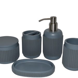 May include: A gray bathroom set featuring a soap dispenser with a silver pump, a toothbrush holder, a small jar with a lid, a soap dish, and a tumbler. Each piece has a ribbed design.