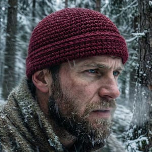 May include: A deep burgundy beanie crafted with a textured crochet stitch pattern. The hat features a thick, folded brim that sits snugly around the head, providing a consistent, dense knit appearance throughout the entire accessory.