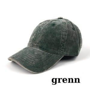 May include: A dark green corduroy baseball cap with a curved brim. The cap has a distressed, vintage look. The word "grenn" is printed in black at the bottom of the image. This hat is a stylish accessory.