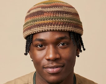 Puede incluir: Un gorro de ganchillo con un patrón de rayas horizontales en tonos tierra de marrón, verde oliva, beige y naranja óxido. El gorro tiene un borde grueso doblado y una construcción tejida texturizada hecha de hilo, cubriendo la parte superior.