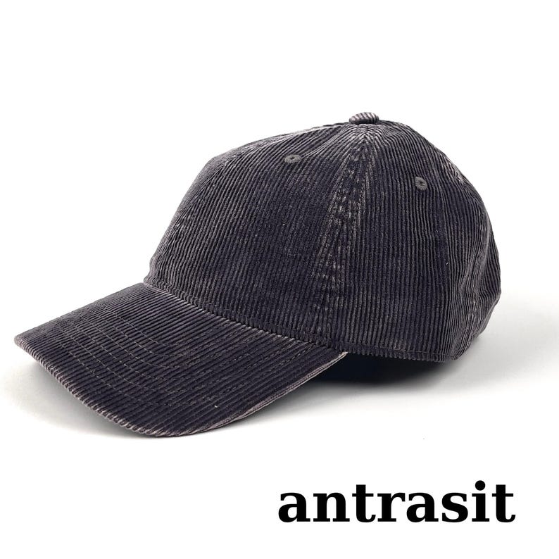 May include: A dark gray corduroy baseball cap with a curved brim. The cap has a six-panel design and a small button on top. The word "antrasit" is printed at the bottom of the image.