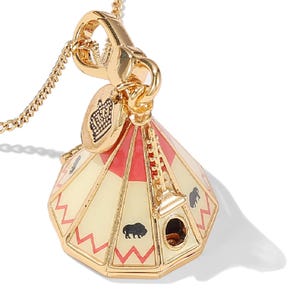 Könnte beinhalten: Goldfarbener Halskettenanhänger in Form eines Tipi, mit roten und cremefarbenen Streifen und schwarzen Büffelsilhouetten. Der Anhänger hat einen kleinen Kronenanhänger und hängt an einer filigranen Kette.