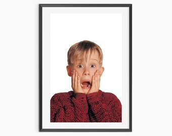 May include: Framed print featuring a young boy with a shocked expression, hands on his cheeks, mouth open. He wears a red sweater against a white background. The image is in a black frame.