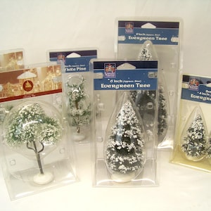 May include: Various sizes of artificial evergreen trees, some with snow-like accents, packaged in clear plastic. The packaging includes labels indicating sizes such as 4, 6, and 9 inches.