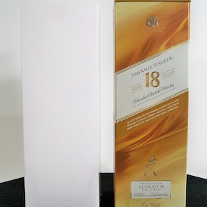 May include: A gold box with a label that reads "Johnnie Walker Aged 18 Years Blended Scotch Whisky". The label also includes the text "The Pursuit of the Ultimate 18 Year Old Blend Distilled, Blended and Bottled in Scotland 750 ml 40% Alc/Vol."