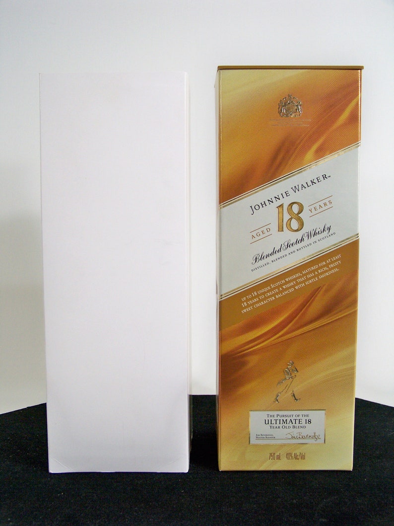 May include: A gold box with a label that reads "Johnnie Walker Aged 18 Years Blended Scotch Whisky". The label also includes the text "The Pursuit of the Ultimate 18 Year Old Blend Distilled, Blended and Bottled in Scotland 750 ml 40% Alc/Vol."