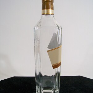 May include: A clear glass bottle with a brown cap and a label that says "Johnnie Walker 18 Years Old".
