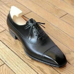 Snygga herrskor i äkta läder, handgjorda i svart kohud med tåspets i oxford-brogue-modell