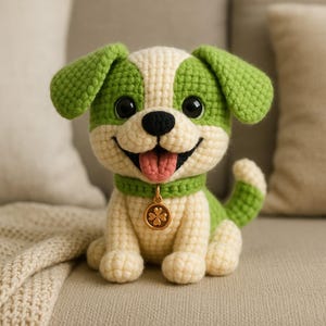 May include: A crocheted dog toy in green and cream colors. The dog has a smiling face with a pink tongue, black eyes, and a green collar with a gold charm. The dog is sitting on a neutral-colored surface.
