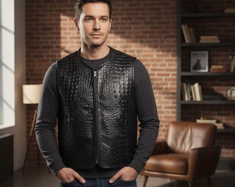 Può includere: Un gilet in pelle nera con una trama a pelle di coccodrillo. Il gilet ha una cerniera a tutta lunghezza e uno scollo tondo. La persona nell'immagine indossa una maglia a maniche lunghe grigio scuro e jeans blu.