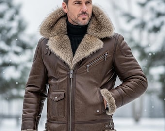 Puede incluir: Chaqueta de cuero marrón con cuello y ribete de piel. La chaqueta tiene cierre de cremallera, múltiples bolsillos y un detalle de cinturón en la cintura. El modelo lleva un cuello alto negro.