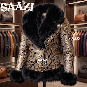 Könnte beinhalten: Eine gold-schwarze Jacke mit Schlangenledermuster, großem schwarzem Kunstfellkragen und passenden Kunstfellmanschetten. Die Jacke verfügt über einen Frontreißverschluss, einen Gürtel mit Schnalle, gesteppte Schulterpartien und den Schriftzug SAAZI.