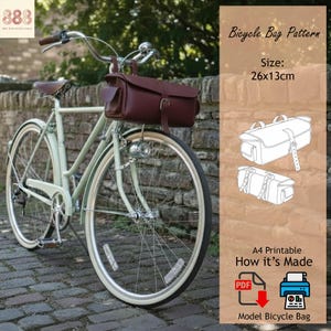 May include: A vintage bicycle with a brown leather bicycle bag attached to the handlebars. The bag is rectangular, with a buckle closure and a small front pocket. The bike is light green with white tires. The image also includes a diagram of the bag and text that reads "Bicycle Bag Pattern".
