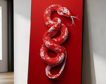 May include: A framed art print featuring a red and white snake against a solid red background. The snake is coiled and has a forked tongue. The artwork is displayed in a black frame and leans against a wall.