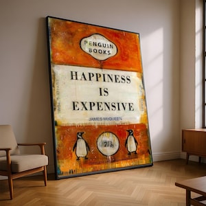May include: Large framed art print with a black border. The artwork features the text "HAPPINESS IS EXPENSIVE" in bold letters, with "Penguin Books" at the top and two penguin illustrations at the bottom. The background is orange and white.