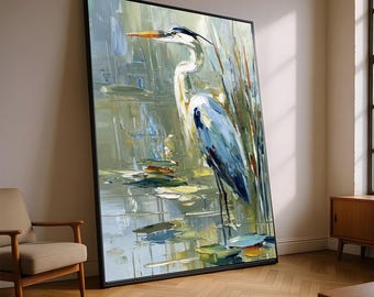 May include: Large framed oil painting of a heron standing in a pond. The artwork features a palette of blues, greens, and whites, with visible brushstrokes. The heron has a long neck and beak, and the painting is leaning against a wall.