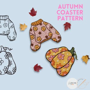 May include: Coasters with an autumn theme. One coaster is shaped like a sweater, and the other is shaped like a pumpkin. Both coasters have a floral pattern. The text "AUTUMN COASTER PATTERN" is in pink. Scattered leaves are also present.
