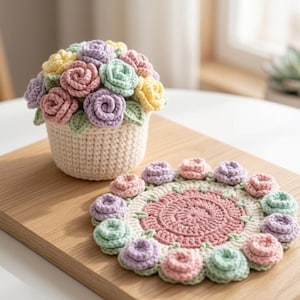 Op de afbeelding: Een gehaakt bloemstuk in een crèmekleurige mand met pastelrozen in roze, paars, geel en groen. Een bijpassende gehaakte onderzetter met een bloemmotief en pastelrozen. Op een houten oppervlak.
