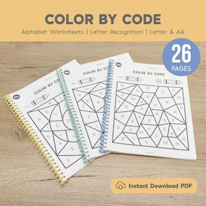 Op de afbeelding: Drie spiraalgebonden werkboeken met de tekst "COLOR BY CODE" en alfabetwerkbladen. De werkboeken hebben een geometrisch ontwerp met letters en cijfers. Een blauwe cirkel met het nummer "26 PAGES" is zichtbaar. De tekst "Instant Download PDF" is ook aanwezig.