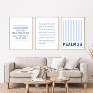 Könnte beinhalten: Drei gerahmte Wandkunstdrucke mit inspirierenden Zitaten und Psalm 23. Die Drucke zeigen Text in Hellblau auf weißem Hintergrund. Die Rahmen sind hellbraun. Die Drucke werden über einem beigen Sofa angezeigt.