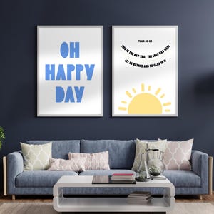 Könnte beinhalten: Zwei gerahmte Kunstdrucke mit inspirierenden Zitaten. Der linke Druck zeigt die Worte "OH HAPPY DAY" in Blau. Der rechte Druck zeigt den Text "PSALM 118:24 THIS IS THE DAY THAT THE LORD HAS MADE LET US REJOICE AND BE GLAD IN IT" und eine gelbe Sonne.