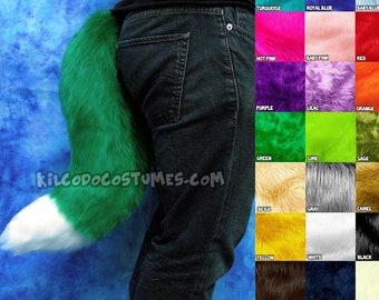 May include: A person wearing jeans with a green and white furry tail attached to their back. The tail is long and fluffy. A color chart with various colors of fur is shown in the background.
