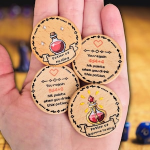 May include: Wooden game tokens with potion designs. One token reads "Potion of Healing" and another says "Potion of Supreme Healing." Other tokens have text that reads "You regain 8d4+8 hit points" and "You regain 4d4+4 hit points."