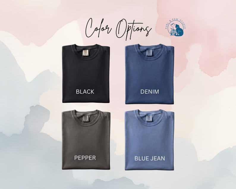May include: Four folded crew neck t-shirts arranged in a grid. The shirts are labeled Black, Denim, Pepper, and Blue Jean. The text Color Options is centered at the top, and a Purl & Paw Studio logo is in the upper right corner.